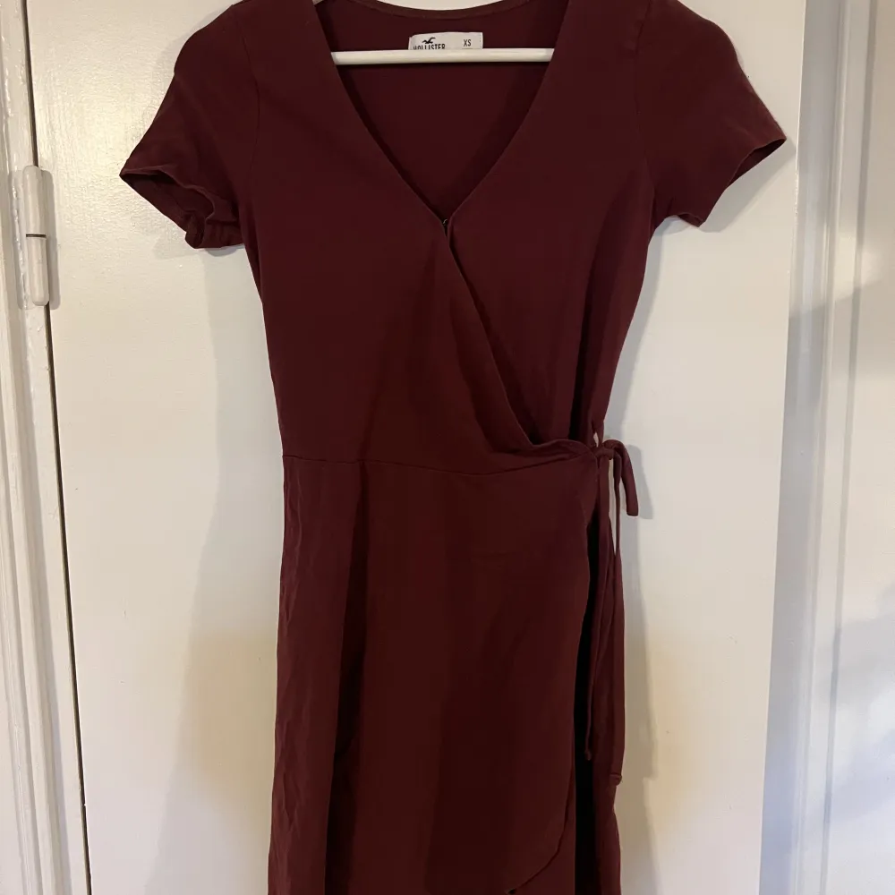 Vinröd klänning från Hollister. Superskönt material med snörning i midjan. . Klänningar.