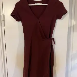 Vinröd klänning från Hollister. Superskönt material med snörning i midjan. 