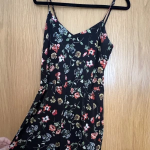 Blommig Romper - Super söt playsuit/romper med flerfärgade blommor på från Stradivarius! Super söt nu på sommaren vid många tillfällen. Mycket bra skick jag säljer bara så jag inte längre använder den💕