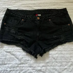 Svarta jeansshorts från H&M, använda ett fåtal gånger och i bra skick. Storlek 38. Midjemått 80 cm, grenhöjd 21 cm. Använd gärna KÖP NU om du vill köpa.