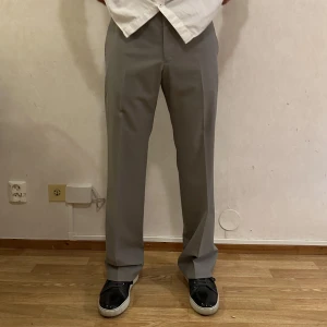 Grå kostymbyxor - Gråa kostymbyxor från Zara, använd en gång. Storlek EU 40 (108.5 cm i längd, 44 cm i midja). Passar 46-48 i europeisk storlek. Nypris: 559 kr, mitt pris: 300 kr. Kontakta mig för frågor eller funderingar!