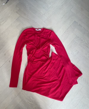 Röd långklänning  - En röd långklänning med skurning vid bröstet. Storlek xs, från NA-KD. Aldrig använd, mycket bra skick. 