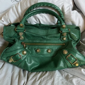 Balenciaga väska - Dags att sälja min älskade balenciaga väska. Den har tyvärr fått en oljefläck på undersidan men inget som syns när den används samt en av nitarna saknas baktill. Köpt second hand och har inget äkthetsbevis, därav lägre pris! Finns mer bilder:)