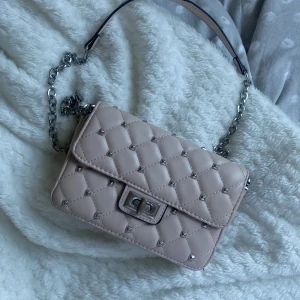 Ljusrosa axelremsväska  - Säljer min axelremsväska ifrån ginatricot. Köpt för några år sedan och har använts några gånger (fått någon liten färgändring på metallen men inget som stör) Inte säker på nypris men är säker på att den kostade över 200. Kom gärna med prisförslag 🥰