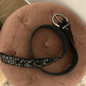 Bälte med silvriga detaljer  - Svart bälte med silvriga detaljer. 