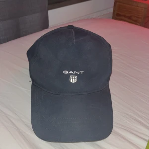 Gant keps mörkgrå - Bra skick, inte använd så ofta, några få år gammal, går att justera storlek