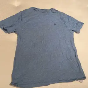 Ralph lauren T-shirt i en snygg blå färg. Står XL (barn) det kan motsvara XS. En perfekt tillskott i garderoben! Först till kvarn.