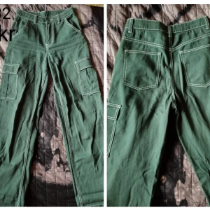 Gröna utsvängda byxor med fickor på sidorna  - Från H&M. Stl. 32. I ett gott skick.