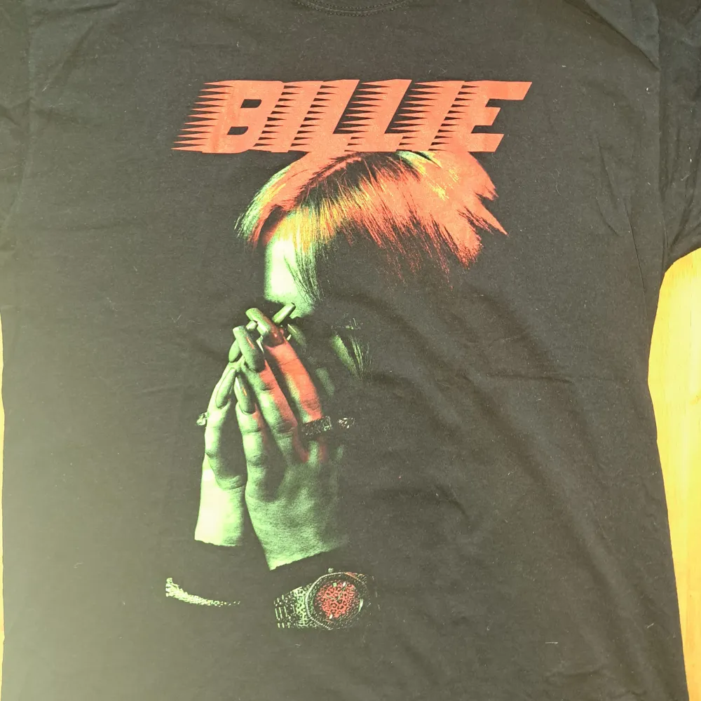 Äkta Billie Eilish t-shirt. Köpte t-shirten för ca ett år sedan på EMP-shop men tröjan har inte kommit till användning och är därför i nyskick. Tröjan kostar 349kr ny. . T-shirts.