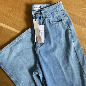 Jättefina helt oanvända vida jeans från NA-KD. Alla lappar sitter kvar, bara den lilla påsen med en extra knapp som har fallit av. Legat i garderoben, därav skrynkliga. Jag är 174 cm för referens 😍🦋 passar mig som normalt är en 36/38 i underdelar!