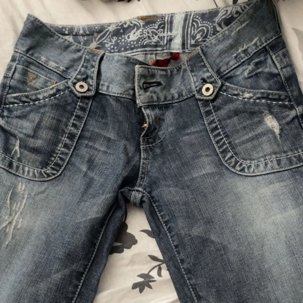 Ett par blå gråa Guess Bootcut jeans med as coola fickor i storlek 26. Dem är lite för småa på mig som vanligtvis har storlek 28. Skriv för bilder me dem på elle om du har några frågor :). Jeans & Byxor.