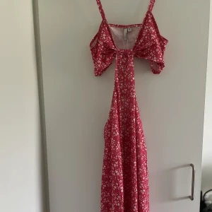 RÖD SOMMARKLÄNNING  - En röd och vit blommig klänning från Nelly helt oanvänd! Med öppning precis under bysten, sitter bra och är sann i storleken❤️