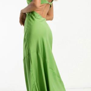 Helt ny klänning, aldrig använd. Fin grön maxiklänning med djup halsringning och utskurna detaljer i midjan.