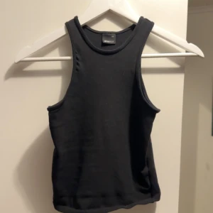 Svart tank top  - Toppen är använd ett fåtal gånger men som just nu bara ligger i garderoben då den inte kommer till användning 