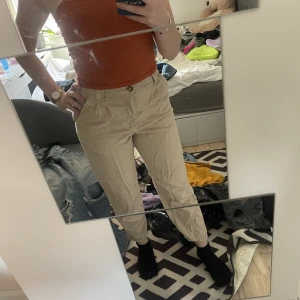Beiga byxor - Endast använda en gång. Medium- high waist. Tyvärr inte strukna i denna bild men annars i väldigt fint skick. Materialet är bomull. 