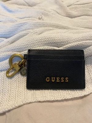 GUESS KORTHÅLLARE - Äkta korthållare från GUESS med en detalj på sidan. Använd men är i nyskick. 