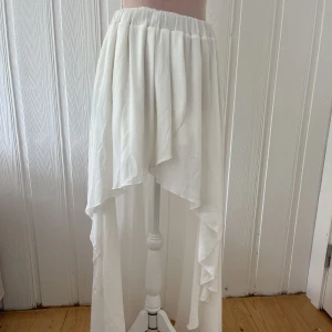 Kjol med släp - En fantastisk kjol med långt släp och härligt tyg. Kjolen är hyfsat genomskinlig med har en kort underkjol. Bra skick med några fläckar på slutet av släpet pga släpats i marken. 