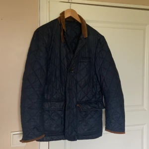 Jacka från Oscar Jacobson - Blå jacka från Oscar Jacobson med armbågslappar i mocka. Ingen större defekter.