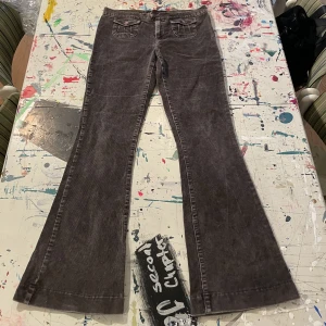 Bruna manchesterbyxor med fina fickor - Lågmidjade utsvängda byxor med jättefina fickor. Midjemått, raktöver: 39cm. Innerbensmått: 77cm.