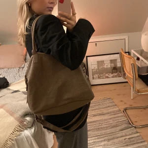 Björn Borg väska - Praktisk och snygg väska från Björn Borg i en mörk beige färg. 25x32 cm. Lite sliten vid fästet av handtagen, som man kan se på sista bilden, därav priset. 