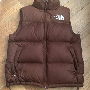 Säljer min North face puffer väst. Färgen heter dark oak vilket är en färg som påminner om brun fast inte riktigt. Skicket är 10/10, finns inte ett ända fel på den, nypris är 2600 på zalando. Storleken är S men kan nog passa M också. 100% äkta 