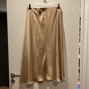 Satin kjol - Lång satinkjol i champagne-färg från H&M. Använd Max 2 gånger. 