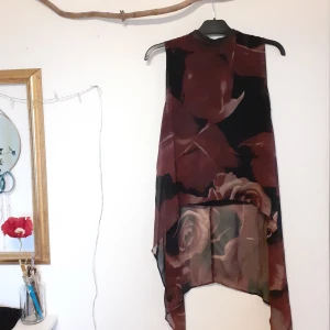 Klänning/tröja - Klänning/ lång tröja med blommor. Dragkedja i ryggen och tyget är lätt genomskinligt. Mycket bra skick och storlek 34 