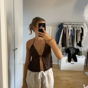 Brun topp med knytning framtill  - Brun topp i plisserat material med knytning framtill. Aldrig använd i storlek S, 50kr+frakt💕 kolla gärna in det andra jag säljer 