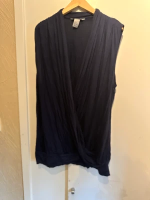 Marinblå toppen - Marinblå topp i skönt material. V ringningen går att ha mer eller mindre stängd. Storlek M. Fint skick. 