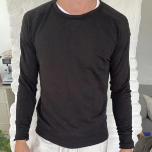 Svart tröja - Säljer denna svarta tröja. Den är i bra skick, dock finns en mindre slitning i resåren på tröjan (se bild två). På grund av detta säljer jag tröjan billigt. Nypris ca 500 kr.