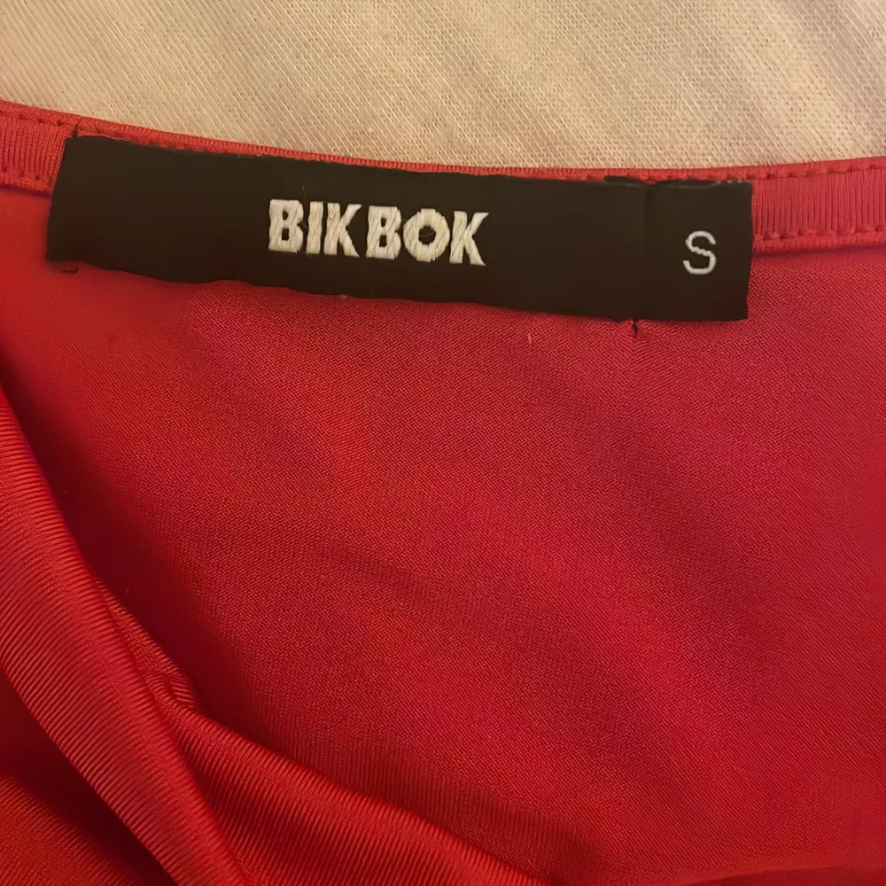 Ett rött fint linne från bikbok. Säljs då den inte kommer till användning. Sista bilden är lånad och visar hur tröjan ser ut ungefär på.. Toppar.