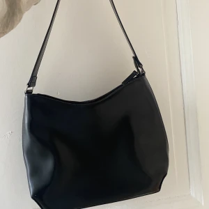 Handväska  - Handväska i läderimitation, rymlig och basic 