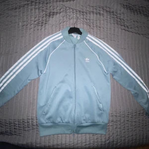 Adidas kofta  - Väldigt vacker färg på denna adidas kofta. Köptes på adidas egna sida och är väldigt sparsamt använd. Den är i en väldigt fin mintig grön/turkos färg och passar väldigt bra nu till våren. Inga skador eller fläckar. Storlek S i dam. 