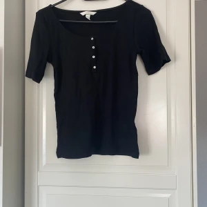 T-shirt - T-shirt med knappar upptill, 20kr+frakt , använd men inga synliga tecken 