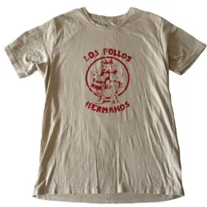 Unik beige T-shirt med handgjort ”Los Pollos Hermanos” tryck på!! OBS! Finns en liten fläck på, fråga för tydligare bild, (Trycket håller i tvätten, tvätta ut och in)