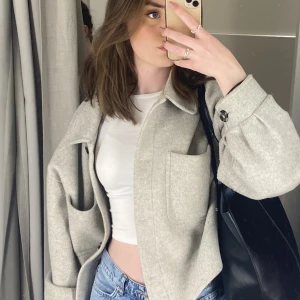 Kort kappa  - Populär kort grå kappa från NA-KD i storlek S. Använd mycket men inga tydliga tecken på slitage. 