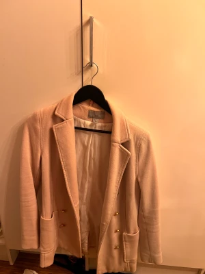 Rosa kavaj - En rosa kavaj från H&M, med guld knappar samt fickor framme.