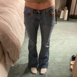 Säljer mina favorit lågmidjade jeans med så coola röda/orange detaljer!!❤️🧡 Köpte secondhand men i jättebra bra skick och väldigt långa men går såklart att vika upp 💙midjemått = 35 cm, innerbenslängd = 88 cm