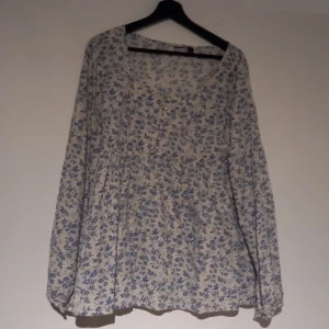 Blus - Fin blå blommig blus med vita pärlor vid bröstet. Jötte snygg!
