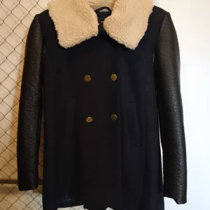 Jacka - Mörkblå vinterjacka med fejkskinn på ärmarna och fejkpäls på kragen. Aldrig använd. Nypris 700kr