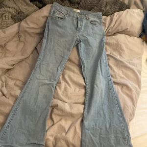 Ljusblå trendiga jeans - Säljer dessa efterfrågade jeans från Gina som är helt slutsålda på både Gina och Nelly! Low waist, storlek 40, bootcut. midjemått rakt över: 40,5cm innerbenslängd:76cm! Inget täcken på slitage!❤️❤️