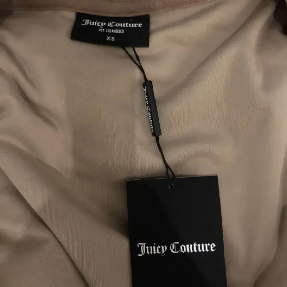 Helt oanvänd juicy couture hoodie, lappen sitter kvar. Vet inte riktigt vad för färg det är men någon slags ljusbrun. . Hoodies.