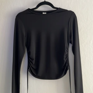 Topp med öppen rygg - En svart topp med öppen rygg från NLY trend. Storlek S. Toppen har aldrig använts och är i fint skick. 