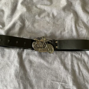Svart skärp med buckel  - Svart skärp med unik belt buckel. Köpt second hand så vet inte vad det är för märke. Skriv gärna vid frågor eller för flera bilder 