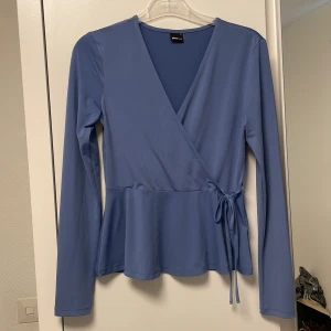 Långärmad blus - GinaTricot - Långärmad blus i storlek S från GinaTricot. Den är helt ny, utan prislapp. Den har en fin blå färg och en elastisk material. 