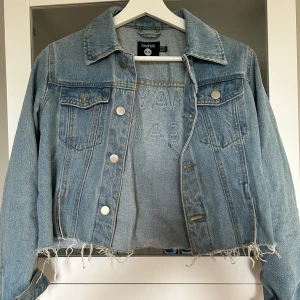Cropped jeansjacka - Jeansjacka i kort modell med tryck på ryggen Från Boohoo Storlek 34