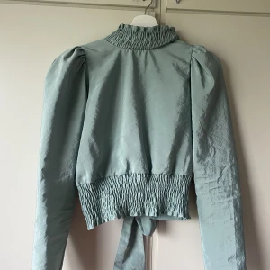 blus - Jättefin blus med öppen rygg och knytning lägnst ner. En av knappanra där uppe är lite sönder men går lätt att laga, tröjan kan användas utan denna knapp utan att det ser konstigt ut. Storlek 36, säljs för 100kr exkls frakt🫶🏼