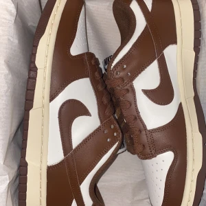 Jordan dunks - Ett par bruna jordan dunks i färgen brun. Aldrig använda i strorlek 38,5 (då de är för stora) köpta från JD. 