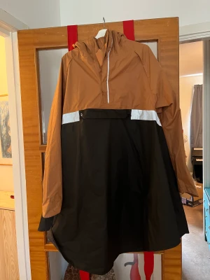 Regnponcho cykling - Regnponcho specialanpassad för cykling. Storlek XS-S men generös i storleken och passar M också. Luva som ej skymmer sikten och remmar att fästa runt benen så att den håller sig på plats.   Sparsamt använd. Nypris 500 kr