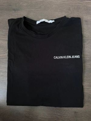 Svart T-shirt  - Helt ny och oanvänd t-shirt från Calvin Klein.   Rensar ur min garderob från en hel del oanvända kläder🌼 Kika och se om du ser något mer i min profil som du gillar så skickar jag med det till dig också!😊 Fler kläder kommer! 